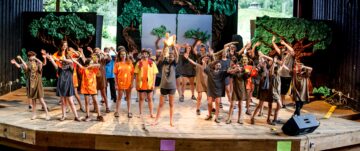 Campers pose while performing the lion king play